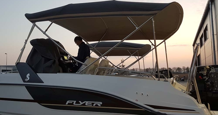 Motorboot mit zweiteiligem Bimini-Top in der Abenddämmerung