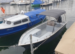Bimini Top 6 Offenes Motorboot mit grauem Bimini-Top im Bootshafen