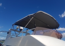 Bimini Top 7 Dunkles Bimini-Top mit Edelstahlgestänge auf einer Motoryacht vor blauem Himmel