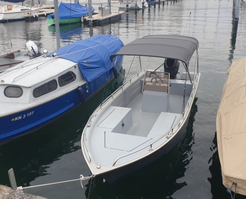 Bimini Top Galerie 8 Offenes Sportboot mit grauem Bimini Top im Bootshafen