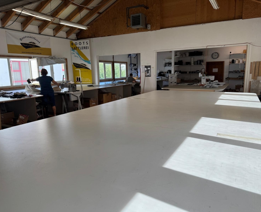 Näherei und Zuschnitt in der Werkstatt der Bootssattlerei Paul Design Grosse Zuschneidetische und Naehmaschinen in der Werkstatt der Bootssattlerei Paul Design