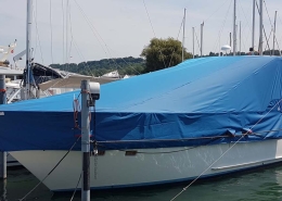 Persenning 2 Motoryacht mit blauer Persenning im Bootshafen