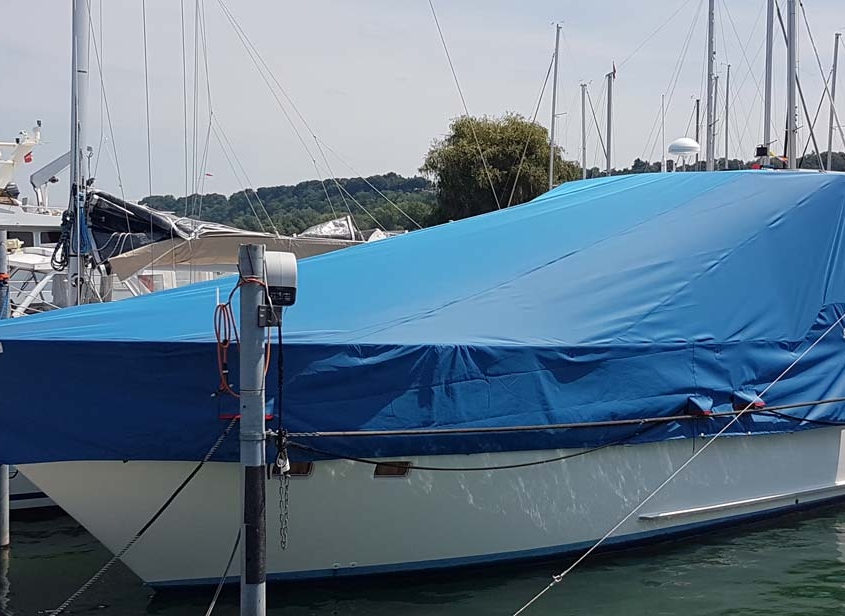 Persenning 2 Motoryacht mit blauer Persenning im Bootshafen