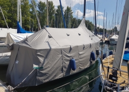 Persenning 4 Graue Zeltpersenning über einem Segelboot am Steg