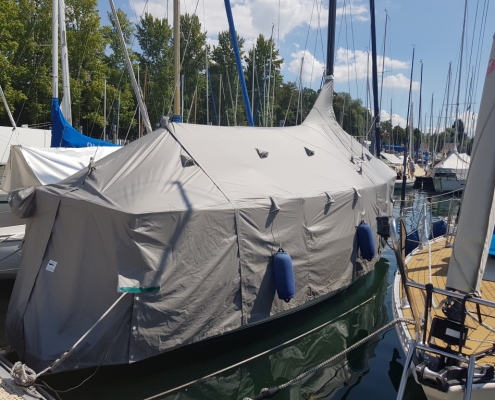 Persenning 4 Graue Zeltpersenning über einem Segelboot am Steg
