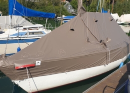 Persenning 7 Segelboot mit brauner Ganzpersenning am Steg im Bootshafen