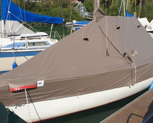 Persenning 7 Segelboot mit brauner Ganzpersenning am Steg im Bootshafen