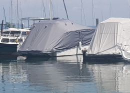 Persenning Galerie 6 Zwei Boote mit grauen Persenningen im Bootshafen