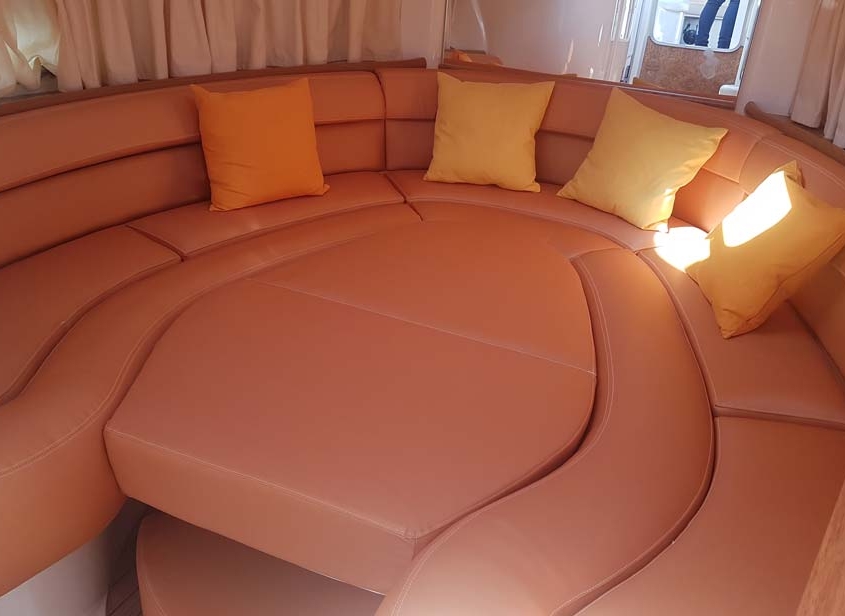 Polster 1 Rundum-Sitzecke mit cognacfarbenen Lederpolstern und gelben Kissen im Bootssalon