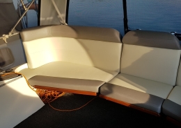 Polster 6 Sitzbank mit beige-grauen Polstern im Cockpit eines Motorboots in der Abendsonne