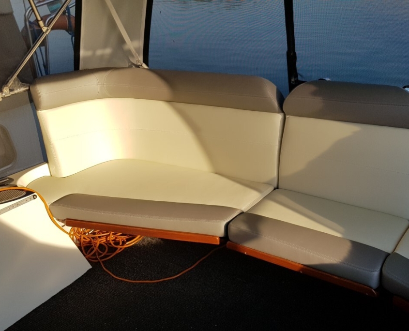 Polster 6 Sitzbank mit beige-grauen Polstern im Cockpit eines Motorboots in der Abendsonne