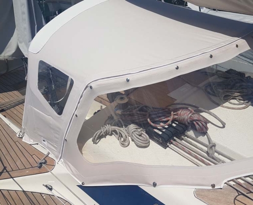 Sprayhood 4 Helle Sprayhood über dem Niedergang einer Segelyacht mit Teakdeck