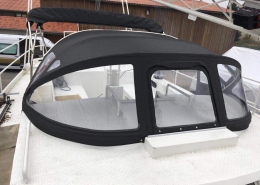 Sprayhood Galerie 2 Schwarze Sprayhood mit großen Klarsichtfenstern auf einem weißen Motorboot