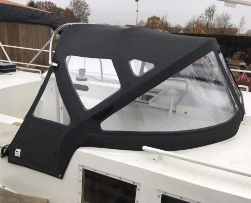 Sprayhood Galerie 3 Schwarze Sprayhood auf Motorboot, seitliche Ansicht mit Edelstahlgestänge