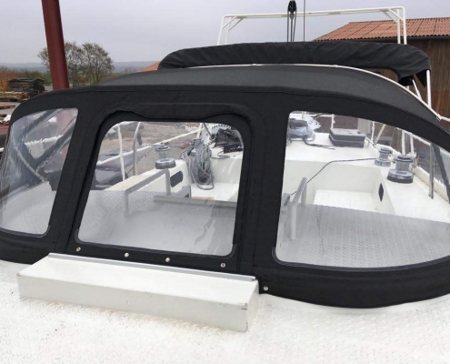 Sprayhood Galerie 7 Sprayhood mit drei Klarsichtfenstern auf weißem Motorboot vor der Werkstatt
