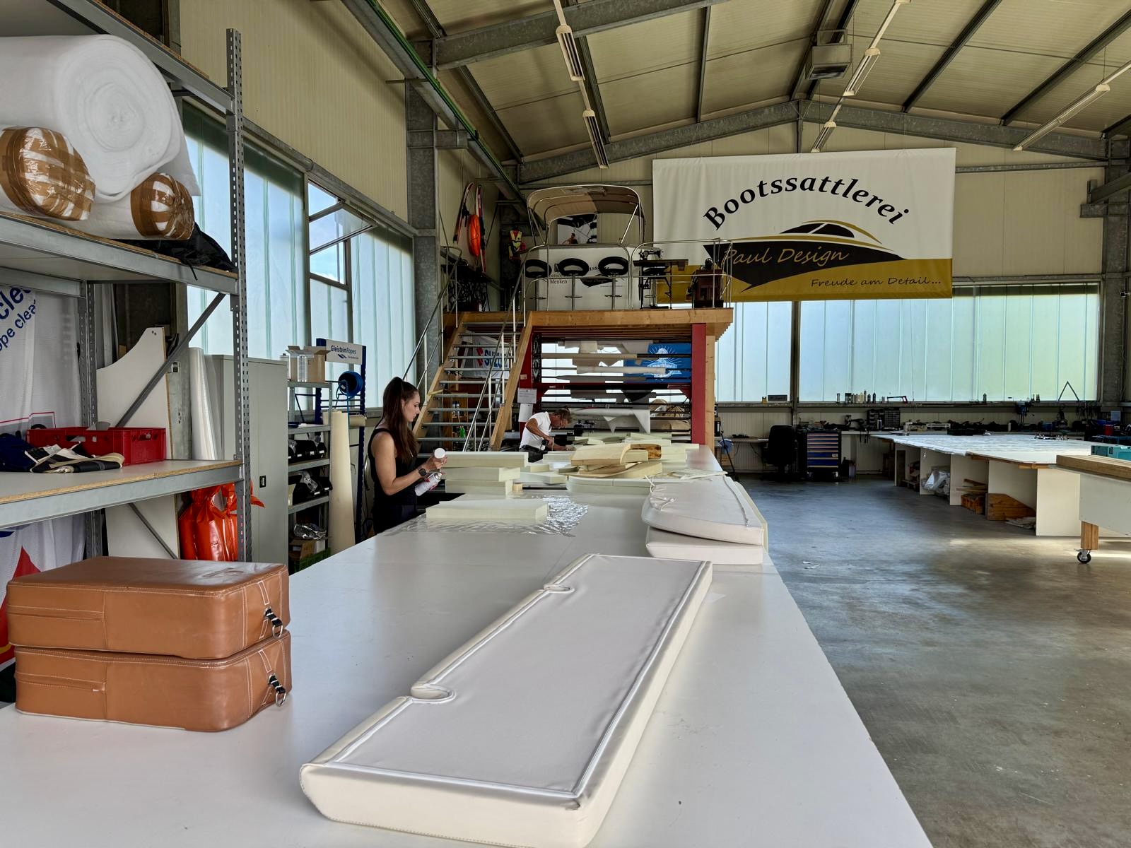 Näharbeitsplatz in der Werkstatt der Bootssattlerei Paul Design Naeharbeitsplatz in der Werkstatt der Bootssattlerei Paul Design mit Polstern und Firmenbanner