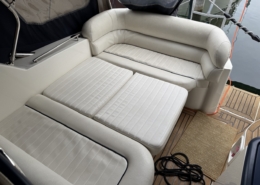 Polster Heck Sonnenliege Weiße Sonnenliege und Sitzpolster im Heck einer Motoryacht