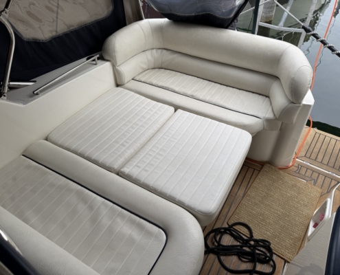 Polster Heck Sonnenliege Weiße Sonnenliege und Sitzpolster im Heck einer Motoryacht