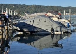 Persenning Ganzabdeckung Grau Graue Ganzpersenning über einem Motorboot am Steg