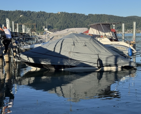 Persenning Ganzabdeckung Grau Graue Ganzpersenning über einem Motorboot am Steg