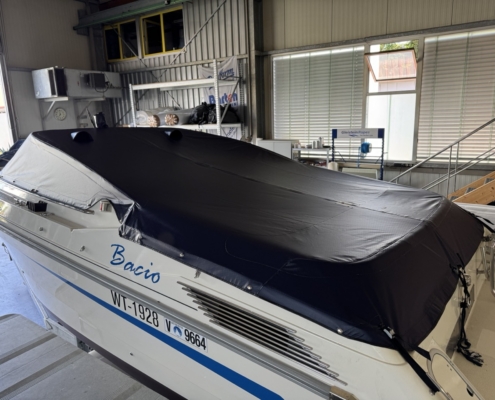 Persenning Cockpit Schwarz Schwarze Cockpitpersenning auf einem Motorboot in der Werkstatt